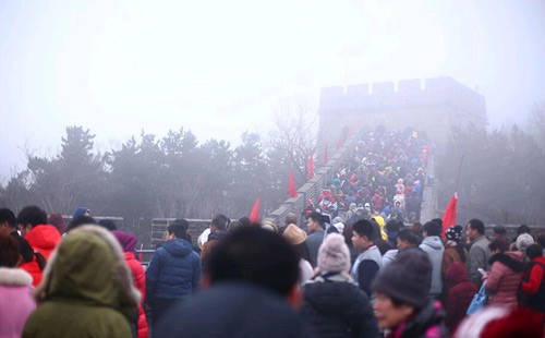 2016年2月11日,正月初四,北京迎重度污染天,空气pm2.5指数 高逼近250,八达岭长城景区游人密集丝毫不受空气污染影响。浓霾天,长城烽火台隐藏在一片灰茫茫的霾色之中。长城上只见人头攒动,数万游客犹如蚂蚁上树,密密麻麻地攀登在城墙过道之上,场面十分震撼。